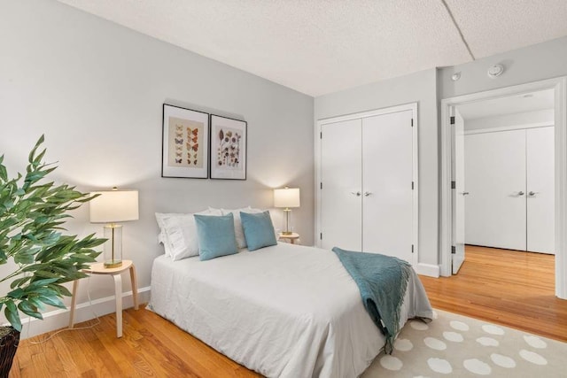 1885 Lexington Ave Unit 5D, New York City, NY 10035 - bedroom featuring wood finished floors, baseboards, a closet, and a textured ceiling