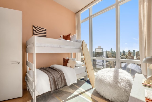 400 Park Ave S Unit 26C, New York City, NY 10016 - bedroom with a skyline view, wood finished floors, vaulted ceiling, and floor to ceiling windows