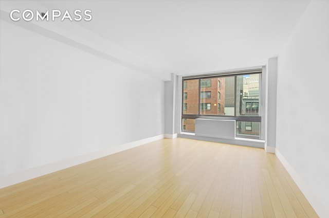242 E 25th St Unit 5B, New York City, NY 10010 - unfurnished room with wood finished floors and baseboards