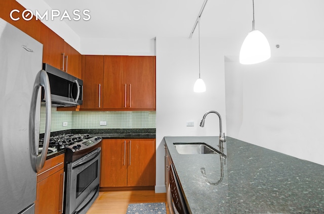 242 E 25th St Unit 5B, New York City, NY 10010 - kitchen with appliances with stainless steel finishes, a sink, light wood-type flooring, and dark stone countertops