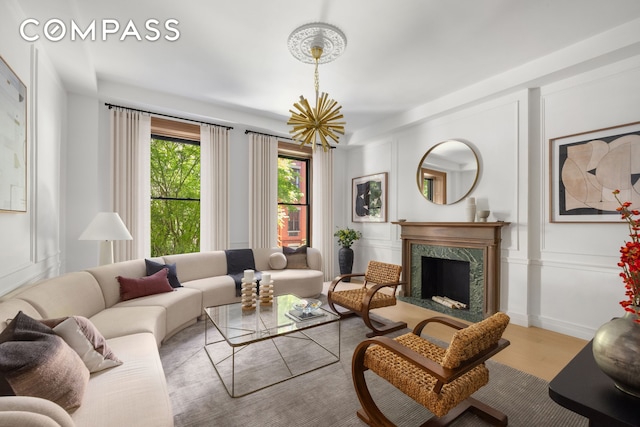 53 W 85th St, New York City, NY 10024 - living area featuring a decorative wall, a high end fireplace, wood finished floors, and a chandelier