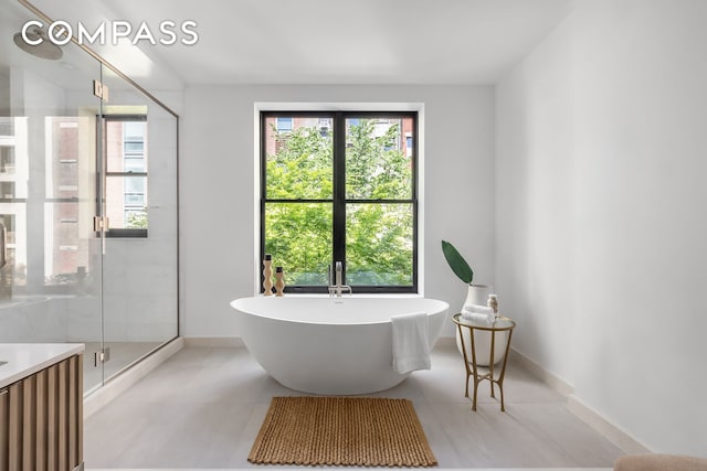 53 W 85th St, New York City, NY 10024 - full bathroom featuring a stall shower, a freestanding bath, plenty of natural light, and tile patterned floors