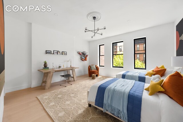53 W 85th St, New York City, NY 10024 - bedroom with baseboards, a chandelier, and wood finished floors
