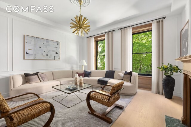 53 W 85th St, New York City, NY 10024 - living area with wood finished floors, a chandelier, and a decorative wall