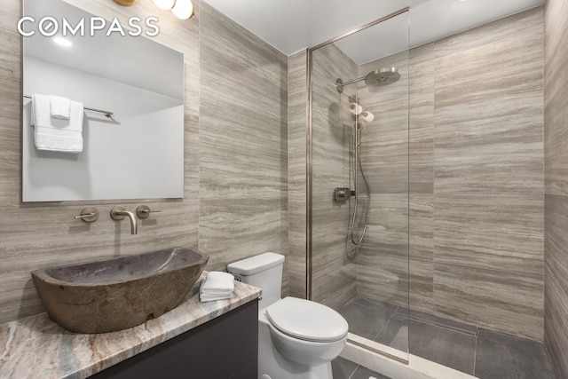 53 W 85th St, New York City, NY 10024 - bathroom with a walk in shower, toilet, vanity, tile walls, and tile patterned flooring