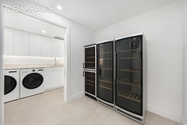 53 W 85th St, New York City, NY 10024 - washroom featuring independent washer and dryer, beverage cooler, and baseboards