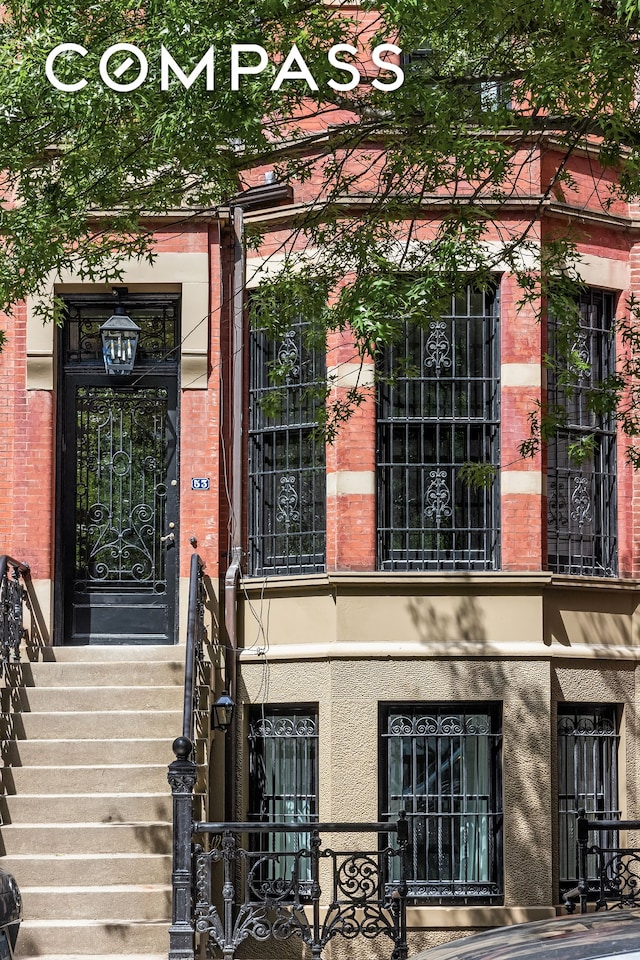 53 W 85th St, New York City, NY 10024 - doorway to property featuring brick siding, a balcony, and stucco siding