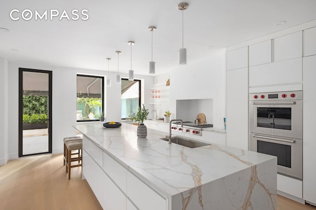 53 W 85th St, New York City, NY 10024 - kitchen with modern cabinets, stainless steel appliances, healthy amount of natural light, and white cabinetry