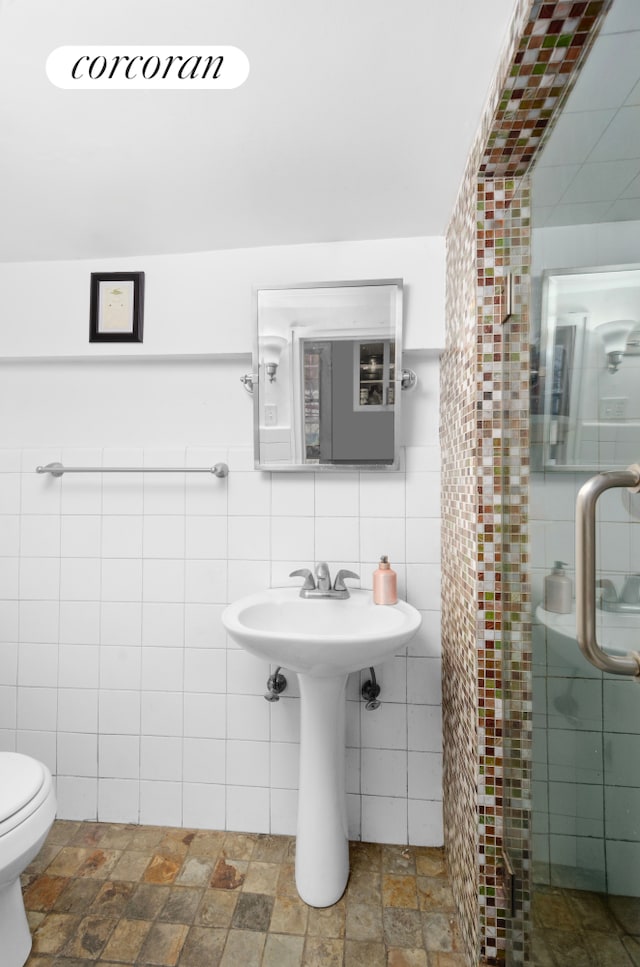 704 Humboldt St, New York City, NY 11222 - bathroom featuring tile walls and stone finish flooring