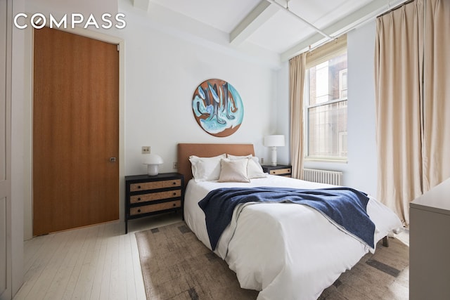 32 W 20th St Unit 5, New York City, NY 10011 - bedroom featuring radiator, beamed ceiling, and hardwood / wood-style flooring