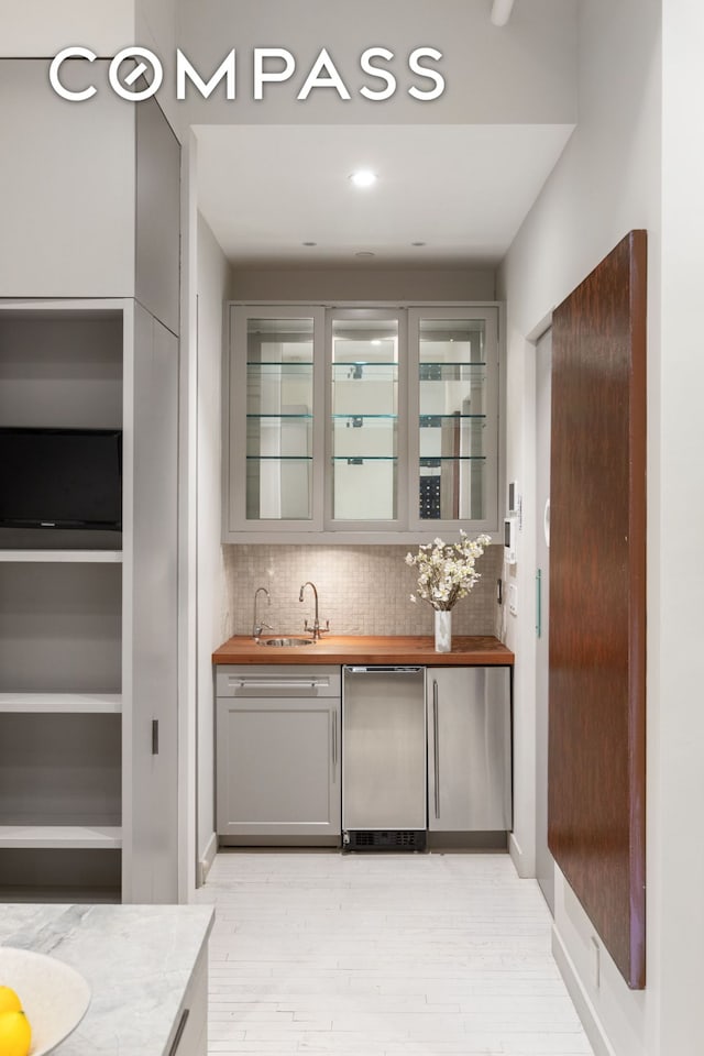 32 W 20th St Unit 5, New York City, NY 10011 - indoor wet bar featuring light wood-style floors, backsplash, and stainless steel dishwasher