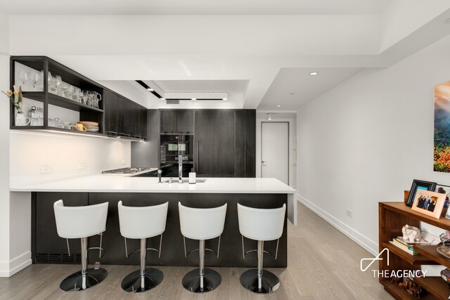 70 Charlton St Unit 4F, New York City, NY 10014 - kitchen with light wood finished floors, a peninsula, light countertops, and recessed lighting