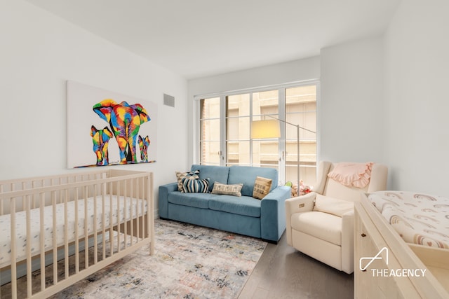 70 Charlton St Unit 4F, New York City, NY 10014 - bedroom featuring a crib and wood finished floors
