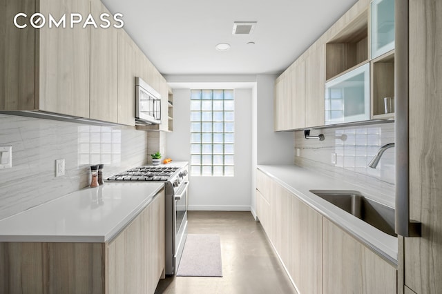 371 W 123rd St Unit 8A, New York City, NY 10027 - kitchen featuring stainless steel appliances, light brown cabinetry, and modern cabinets