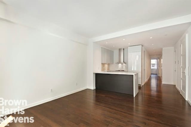 27 W 19th St Unit 7, New York City, NY 10011 - unfurnished living room with dark wood-style floors and baseboards