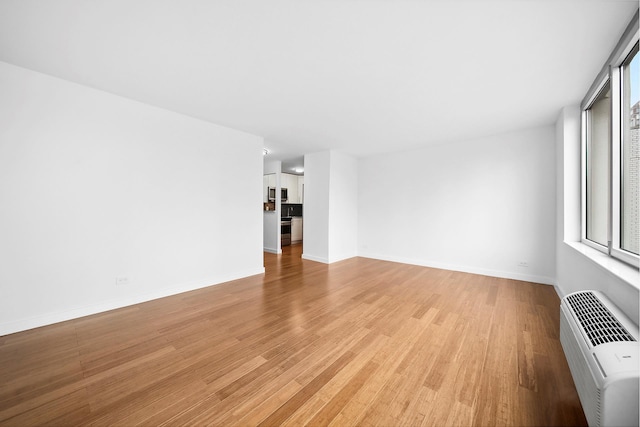 353 E 72nd St Unit 20B, New York City, NY 10021 - spare room featuring light wood finished floors and a wall mounted air conditioner