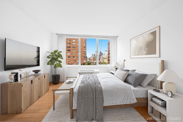 353 E 72nd St Unit 20B, New York City, NY 10021 - bedroom with light wood finished floors and a city view