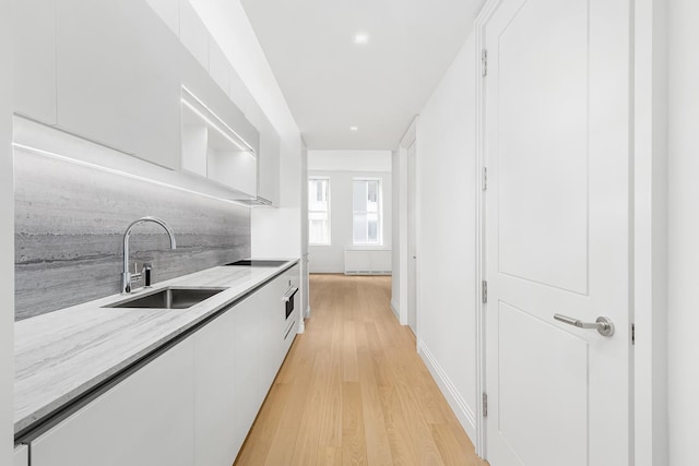 1 Wall St Unit 1116, New York City, NY 10005 - kitchen featuring a sink, white cabinets, modern cabinets, light wood finished floors, and open shelves