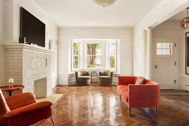 216 E 21st St, New York City, NY 11226 - sitting room featuring a wainscoted wall, a decorative wall, a fireplace, and ornate columns