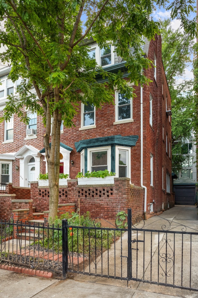 216 E 21st St, New York City, NY 11226 - view of front of house featuring brick siding, a fenced front yard, and an outbuilding