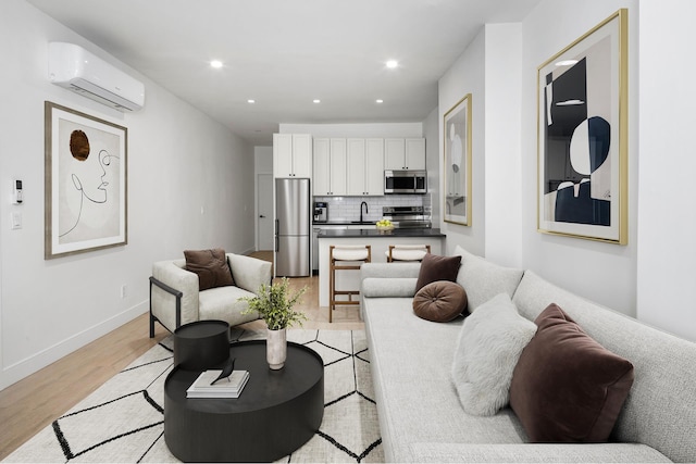 45 Cornelia St, New York City, NY 11221 - living room with an AC wall unit, light wood finished floors, recessed lighting, and baseboards