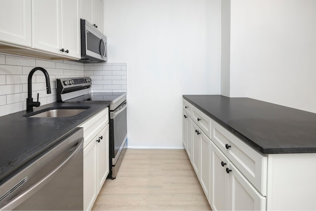 45 Cornelia St, New York City, NY 11221 - kitchen with appliances with stainless steel finishes, a sink, dark countertops, backsplash, and light wood-style floors