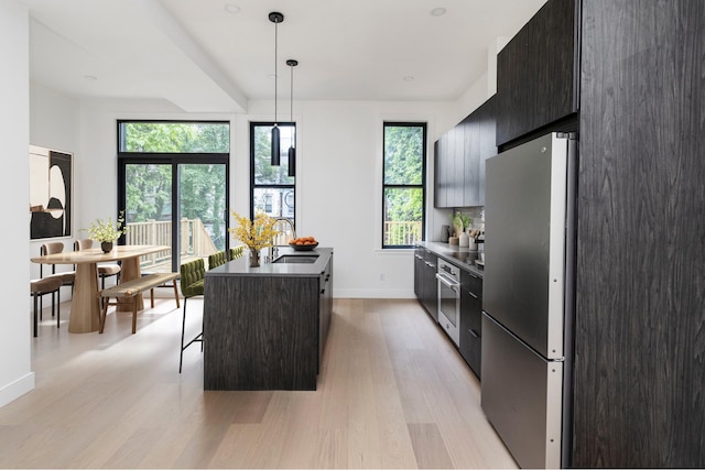 45 Cornelia St, New York City, NY 11221 - kitchen with freestanding refrigerator, modern cabinets, a sink, light wood-style flooring, and an island with sink