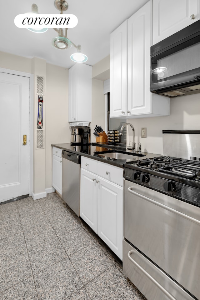 142 E 49th St Unit 2C, New York City, NY 10017 - kitchen featuring stainless steel appliances, a sink, granite floors, baseboards, and white cabinets