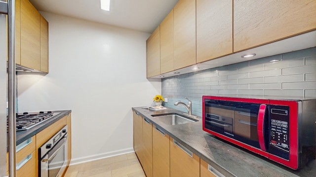 310 W 52nd St Unit 17A, New York City, NY 10019 - kitchen with appliances with stainless steel finishes, a sink, dark countertops, backsplash, and baseboards