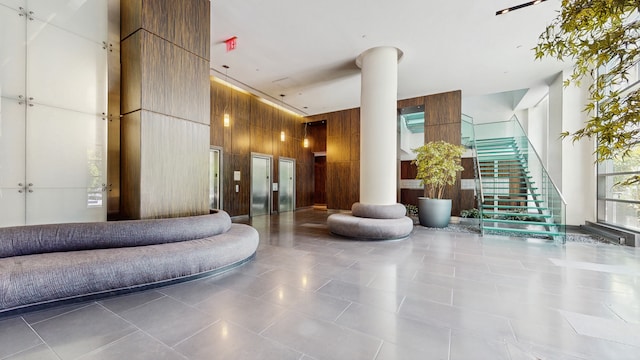 310 W 52nd St Unit 17A, New York City, NY 10019 - common area with a towering ceiling, wooden walls, and stairway