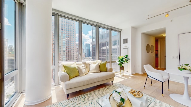 310 W 52nd St Unit 17A, New York City, NY 10019 - living area featuring a city view, light wood-style flooring, and baseboards