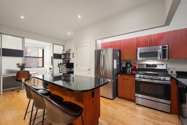 20 W St Unit 15H, New York City, NY 10004 - kitchen with stainless steel appliances, dark countertops, light wood-style flooring, and recessed lighting