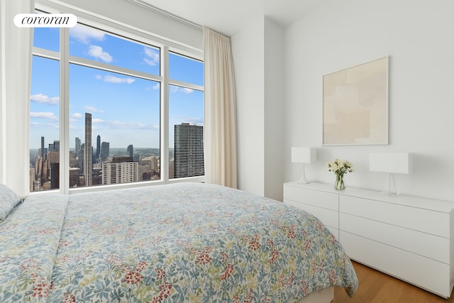 151 E 58th St Unit 42C, New York City, NY 10022 - bedroom with wood finished floors and a view of skyline