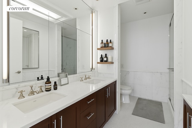 151 E 58th St Unit 42C, New York City, NY 10022 - bathroom featuring double vanity, toilet, an enclosed shower, wainscoting, and tile walls