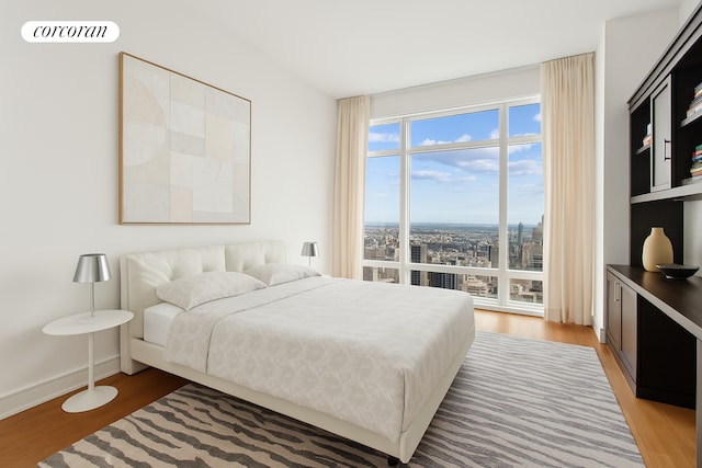 151 E 58th St Unit 42C, New York City, NY 10022 - bedroom with light wood-type flooring and a view of city