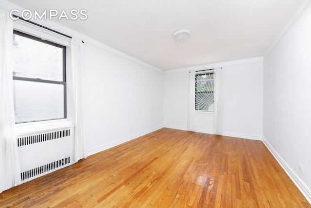 221 E 18th St Unit 5F, New York City, NY 11226 - spare room with radiator heating unit, light wood-style floors, and crown molding