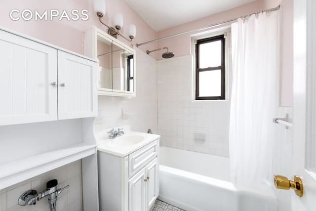 221 E 18th St Unit 5F, New York City, NY 11226 - bathroom featuring vanity, shower / bath combo with shower curtain, and tile walls