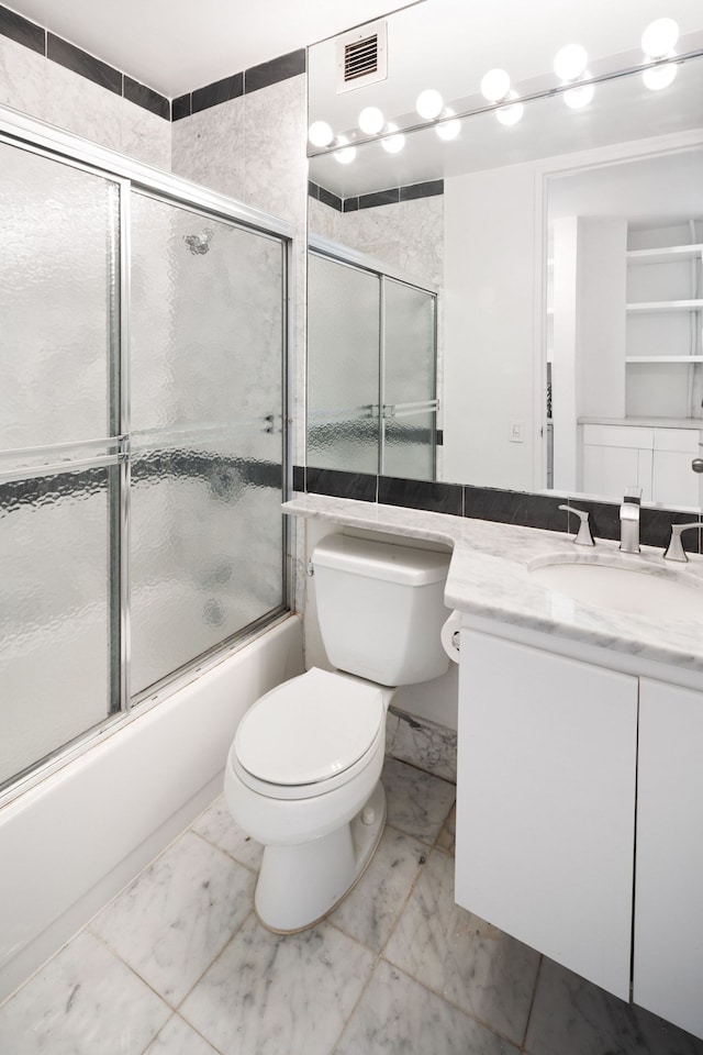 500 W 43rd St Unit 3C, New York City, NY 10036 - bathroom with marble finish flooring, bath / shower combo with glass door, toilet, and vanity