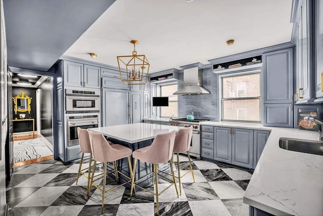 40 E 78th St Unit 6H, New York City, NY 10075 - kitchen featuring stainless steel appliances, gray cabinets, wall chimney range hood, a chandelier, and a sink