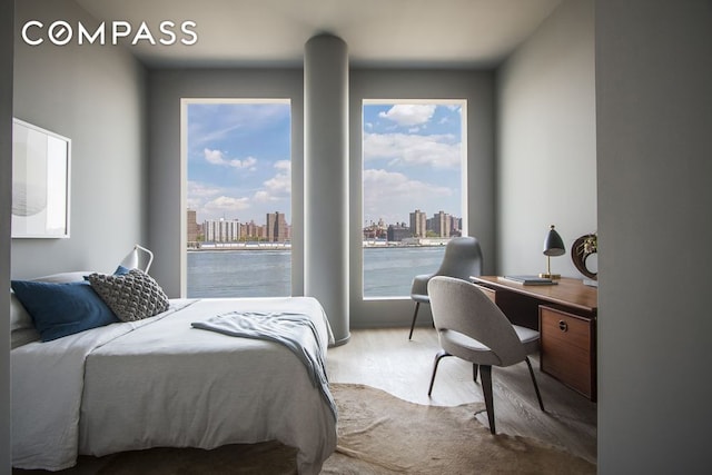 1 John St Unit 3B, New York City, NY 11201 - bedroom with wood finished floors, a view of skyline, and a desk