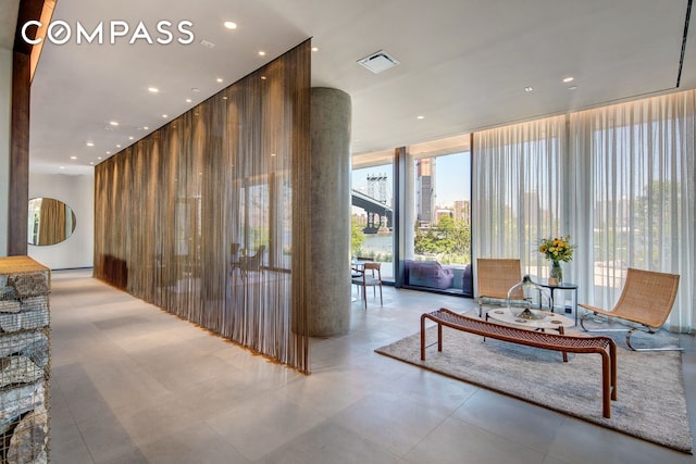 1 John St Unit 3B, New York City, NY 11201 - community lobby featuring floor to ceiling windows, a high ceiling, a city view, recessed lighting, and wooden walls