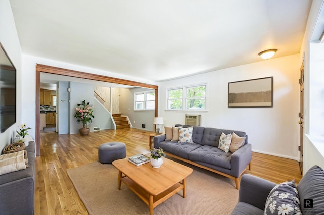 118 Stobe Ave, New York City, NY 10306 - living area with stairs, light wood-type flooring, a wall mounted air conditioner, and baseboards