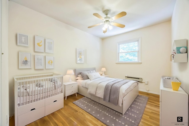 118 Stobe Ave, New York City, NY 10306 - bedroom with a baseboard heating unit, wood finished floors, ceiling fan, and baseboards