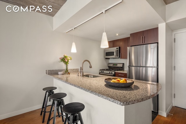 555 W 23rd St Unit S12B, New York City, NY 10011 - kitchen featuring appliances with stainless steel finishes, a sink, a kitchen breakfast bar, a peninsula, and baseboards