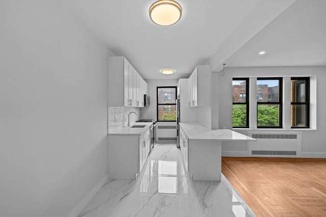 43-25 43rd St Unit 5D, New York City, NY 11104 - kitchen with radiator, baseboards, white cabinets, decorative backsplash, and recessed lighting