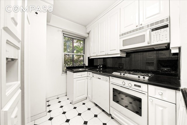 11 5th Ave Unit 3L, New York City, NY 10003 - kitchen featuring white appliances, dark countertops, white cabinets, decorative backsplash, and light flooring