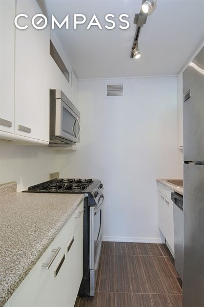 300 Rector Pl Unit 4E, New York City, NY 10280 - kitchen with appliances with stainless steel finishes, white cabinets, and light stone countertops
