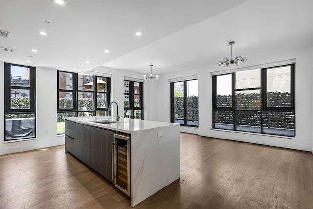 11 Hancock Pl Unit 304, New York City, NY 10027 - kitchen with a chandelier, a sink, wine cooler, hardwood / wood-style floors, and an island with sink