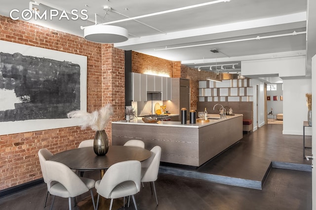 36 W 15th St Unit 4, New York City, NY 10011 - dining area with brick wall and dark wood-style flooring