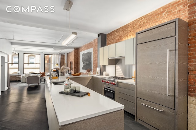 36 W 15th St Unit 4, New York City, NY 10011 - kitchen with brick wall, appliances with stainless steel finishes, modern cabinets, light countertops, and open floor plan